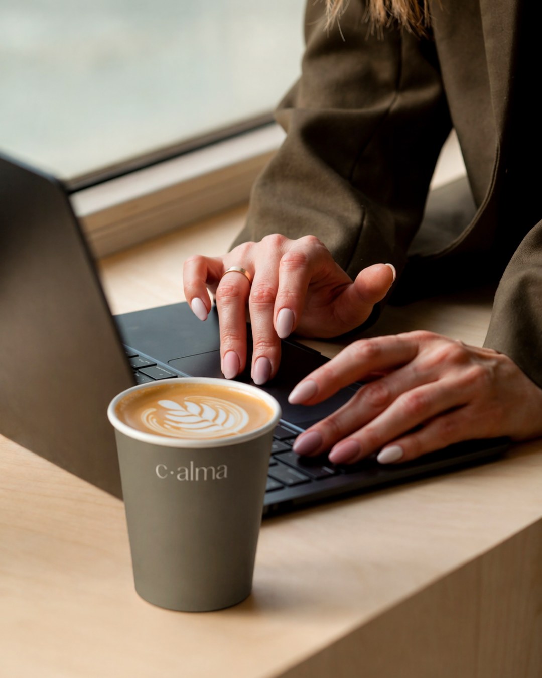 A c·alma coffee cup on the desk at CALMA
